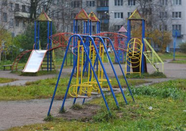 Salgın sırasında sonbaharda bahçedeki boş bir çocuk parkında sallanmak.