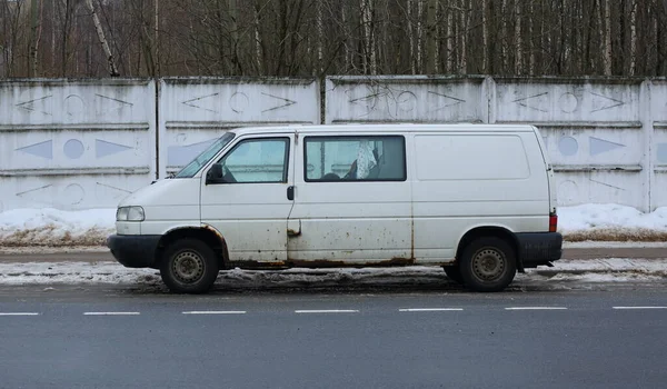Oude Roestige Witte Minivan Geparkeerd Aan Een Grijs Betonnen Hek — Stockfoto
