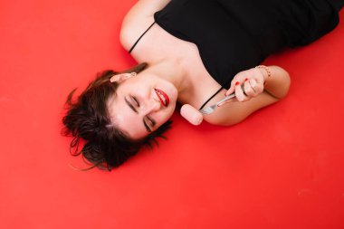 Siyah elbiseli bir kız çatalda sosis tutuyor.