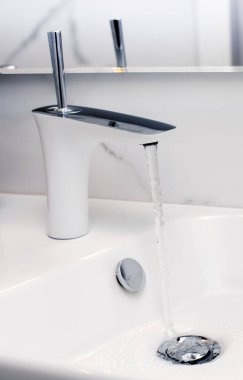 Musluğu aç ve lavaboya su dök.