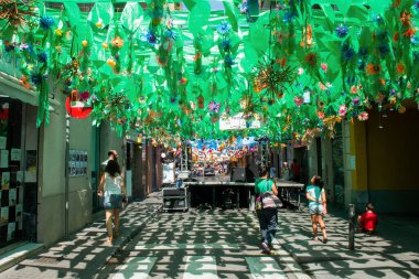 08-21-2015 Barcelona Spain: Citizens admire a street adorned with plastics in the shape of plants and flowers during the summer festivities in the Gracia neighborhood in Barcelona