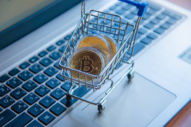 Dizüstü bilgisayarda alışveriş arabasındaki altın bitcoin, dijital para birimi para kripto para, blok zinciri ve finans konsepti ticareti.