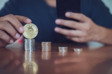 Bitcoin 'i tutan adam bitcoin, Cryptocurrency modern finansal ve tüccar konseptine odaklı akıllı telefon kullanıyor..
