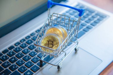 Dizüstü bilgisayarda alışveriş arabasındaki altın bitcoin, dijital para birimi para kripto para, blok zinciri ve finans konsepti ticareti.