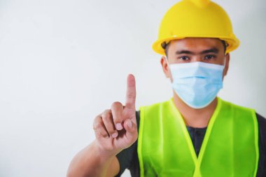 Tıbbi maskeli mühendis, seçilmiş parmak üzerine odaklanmış şeffaf ekran ekranına dokunuyor. Yapılandırma Konsepti.