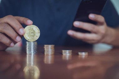 Bitcoin 'i tutan adam bitcoin, Cryptocurrency modern finansal ve tüccar konseptine odaklı akıllı telefon kullanıyor..