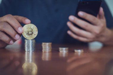 Bitcoin 'i tutan adam bitcoin, Cryptocurrency modern finansal ve tüccar konseptine odaklı akıllı telefon kullanıyor..