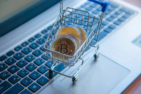 Dizüstü bilgisayarda alışveriş arabasındaki altın bitcoin, dijital para birimi para kripto para, blok zinciri ve finans konsepti ticareti.
