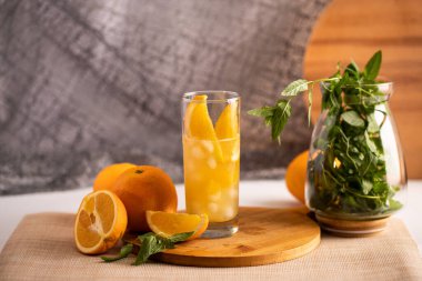 Portakallı, portakal dilimli ve buzlu bir bardakta.