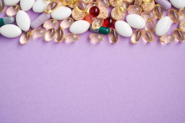 Pembe arka planda vitaminler ve tabletler