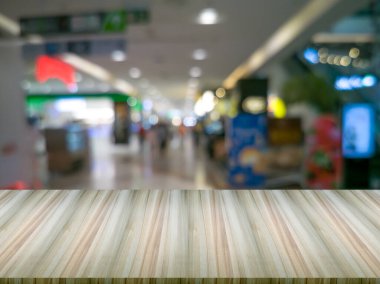 Öndeki yapay ahşap masa. Bulanık arka plan ve yuvarlak bokeh bir alışveriş merkezidir..