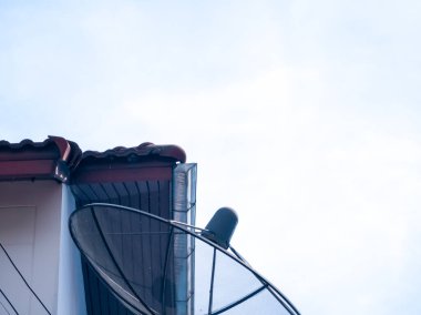 Çatısı oluklu, uydu antenli, bulutsuz gökyüzü arkaplanlı. Tayland kışı 