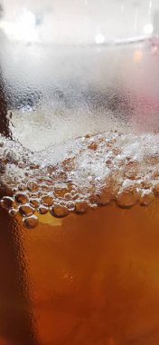 Buzlu bir bardak suda hafif bir içecek.