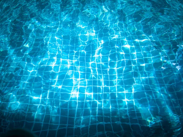在假日的晚些时候 蓝色的游泳池里的水 波浪和阳光的反射 在画面的底部有黑暗的影子 — 图库照片