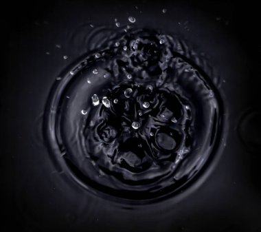 Su damlacıkları, siyah bir zemin üzerinde daire şeklinde etrafa saçılmış su damlacıkları saçar. Siyah bir zemin üzerinde kırmızı bir daire çizer..