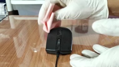 Kamera 4K, yakın plan. Alkol spreyi ve temizlik bezi kullanarak siyah fareyi sil. (Beyaz eldiven giyen insanlar) Covid-19 ve diğer patojenlere karşı korumak için..