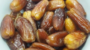 Kamera HD 1080P ile dolu. Beyaz bir fincanda bir yığın hurma yavaşça döner. Tropik bitkiler.