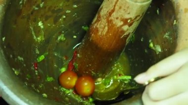 Tam HD 1080 p yakın çekim İnsanlar (eller), popüler baharatlı Tayland yemeği olan papaya salatası (Papaya Pok Pok) yapmak için domatesleri havana koyuyorlar..