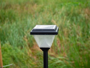 Yakın plan, güneş ışığı açık havada, evler, binalar ve yağmur sonrası su damlacıkları için, yeşil ve bulanık çimen arka plan