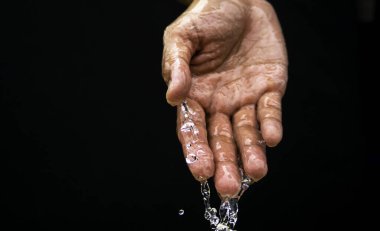 Water flows on the palm of the hand down below. The purity of the water.The benefits of water. conditions of drought and natural disasters.