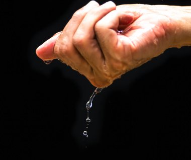 The human hand holds water with his hands and the water drops below. The purity of the water.The benefits of water. conditions of drought and natural disasters.