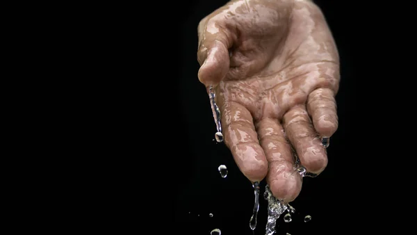 Water flows on the palm of the hand down below. The purity of the water.The benefits of water. conditions of drought and natural disasters.