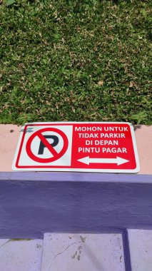 İçinde sembol bilgisi olan demir bir levhanın fotoğrafı ve çitin önüne park etmemek için temyiz başvurusu