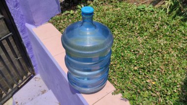 Bir kurye tarafından avluya yerleştirilmiş bir galon içme suyunun fotoğrafı.