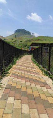 Endonezya 'nın Cicalengka Rüya Diyarı' nın her iki tarafında demir çitlerle çevrili küçük bir yolun fotoğrafı.