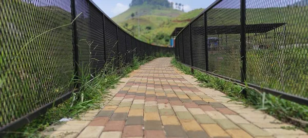 インドネシアのCicalengka Dreamlandの観光地の両側に鉄柵で囲まれた小さな道路の写真 — ストック写真