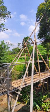 Endonezya 'nın Cikancung bölgesinde bir nehrin üzerinde bambu köprüsü. 