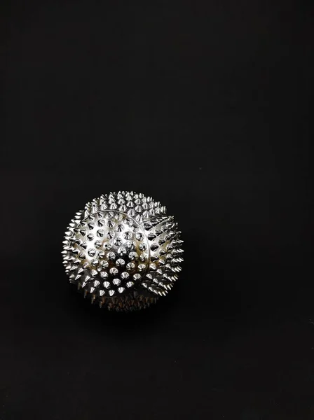 Photo of spiked silver ball isolated on black background