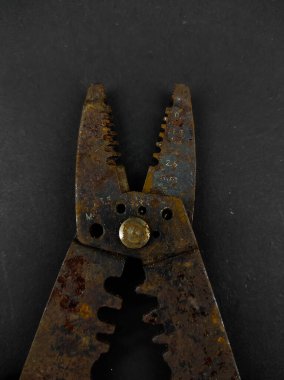 Paslı tel sökücü pense fotoğrafı siyah arkaplanda izole edilmiş.