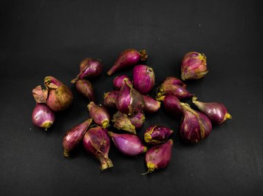 Siyah bir arkaplanda izole edilmiş birkaç arpacık soğanı fotoğrafı