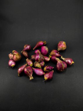 Siyah bir arkaplanda izole edilmiş birkaç arpacık soğanı fotoğrafı