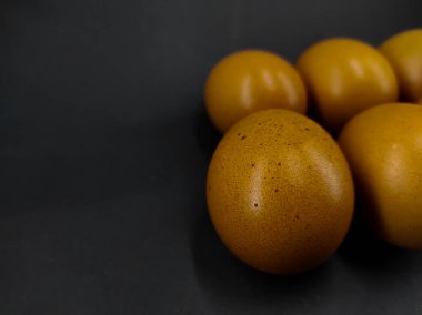 Bir grup çiğ yumurtanın siyah arka planda izole edilmiş fotoğrafı.