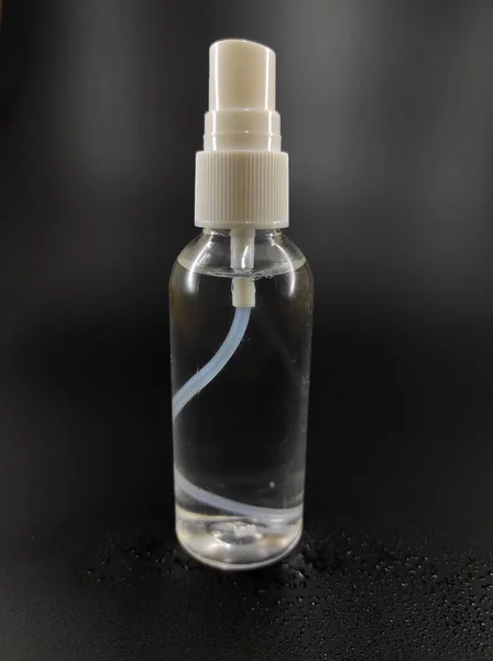 黒い背景に単離されたハンドサニタイザー液体を含むボトルの写真ではなく フォーカス — ストック写真