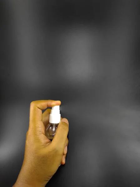 Siyah Arka Planda Izole Edilmiş Dezenfektanı Şişesi Tutan Ellerin Fotoğrafı — Stok fotoğraf
