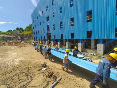 Gorontalo, Endonezya - 09 Kasım 2017: Mavi metal plakayı kaldırmak için birlikte çalışan bir grup işçinin fotoğrafı