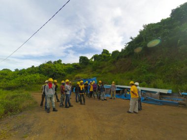 Gorontalo, Endonezya - 23 Temmuz 2017: Bir inşaat sahasında çalışmadan önce güvenlik alet çantası toplantısı yapan bir grup işçinin fotoğrafı