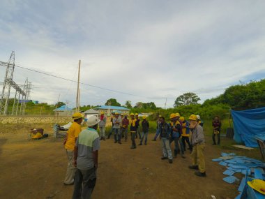 Gorontalo, Endonezya - 23 Temmuz 2017: Bir inşaat sahasında çalışmadan önce güvenlik alet çantası toplantısı yapan bir grup işçinin fotoğrafı