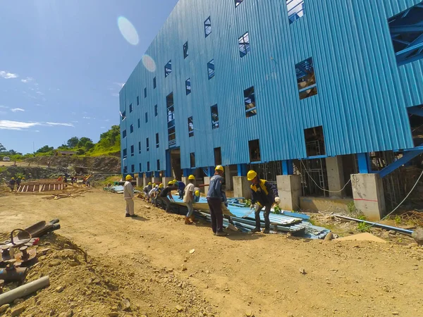 Gorontalo, Endonezya - 09 Kasım 2017: Mavi metal plakayı kaldırmak için birlikte çalışan bir grup işçinin fotoğrafı