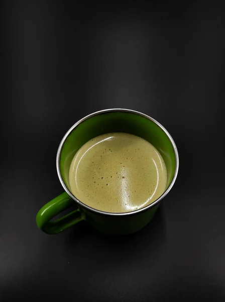 Photo Glass Green Cup Containing Cappuccino Coffee Isolated Black Background — стоковое фото