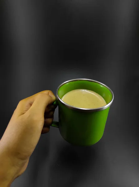 Photo Hand Holding Cup Coffee Green Cup Isolated Black Background — Stockfoto