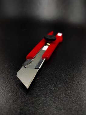 Keskin kırmızı kesici bir bıçağın fotoğrafı siyah arka planda izole edilmiş, Odaklanma değil.