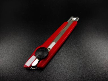 Keskin kırmızı kesici bir bıçağın fotoğrafı siyah arka planda izole edilmiş, Odaklanma değil.