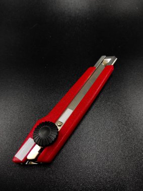 Keskin kırmızı kesici bir bıçağın fotoğrafı siyah arka planda izole edilmiş, Odaklanma değil.