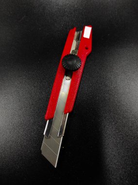 Keskin kırmızı kesici bir bıçağın fotoğrafı siyah arka planda izole edilmiş, Odaklanma değil.