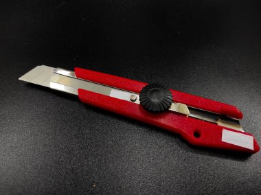 Keskin kırmızı kesici bir bıçağın fotoğrafı siyah arka planda izole edilmiş, Odaklanma değil.