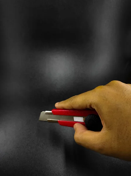 Photo Hand Holding Cutter Knife Isolated Black Background Focus — Fotografie, imagine de stoc
